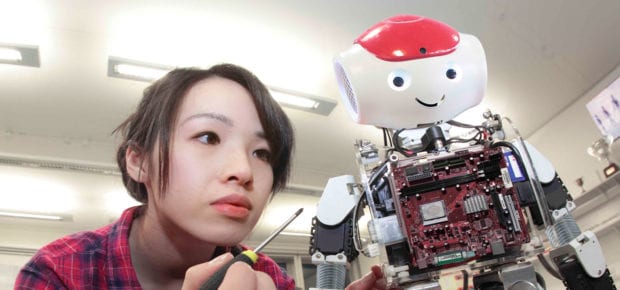 engineer woman working on a robot with screwdriver