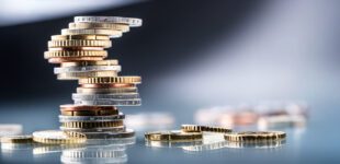 Euro coins built in the shape of a tower that balances before falling, a symbol of financial growth and fall - Close Up